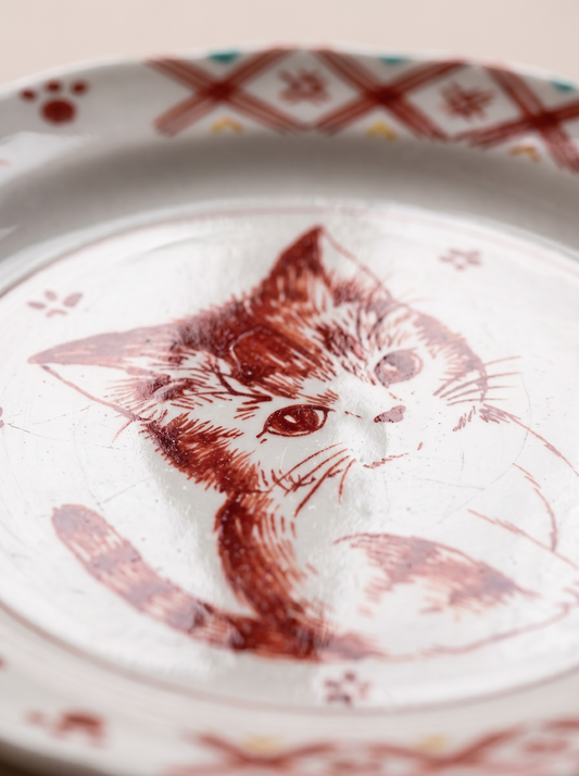 Decorative plate with a red cat illustration on a white background