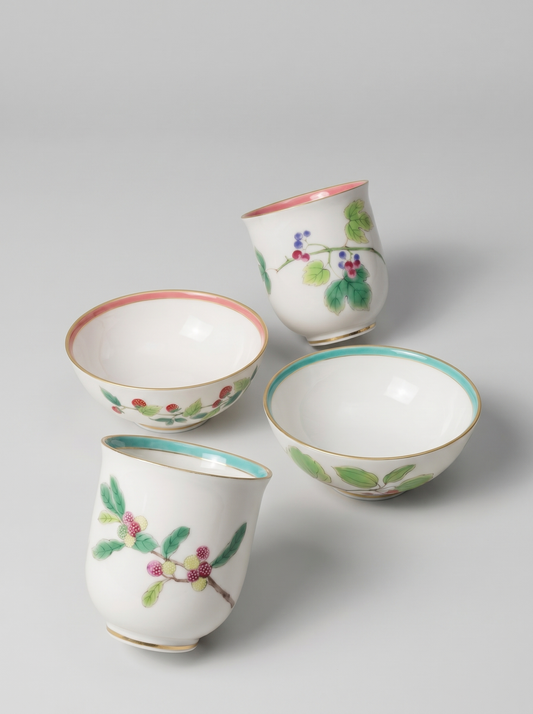Set of four Japanese koransha porcelain cups with floral designs on a light gray background
