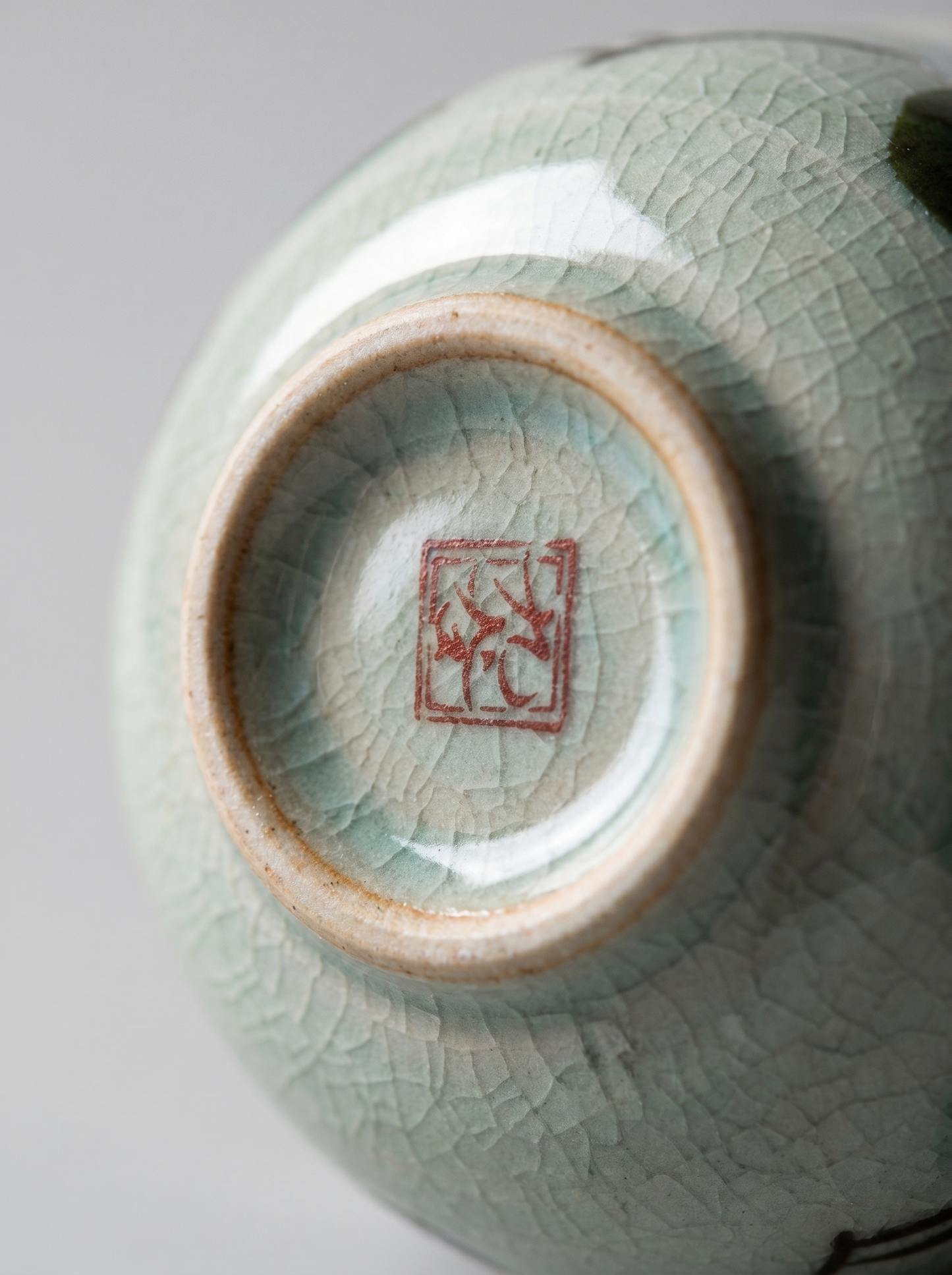 Close-up of a ceramic bowl cup a visible brand logo on a light gray background