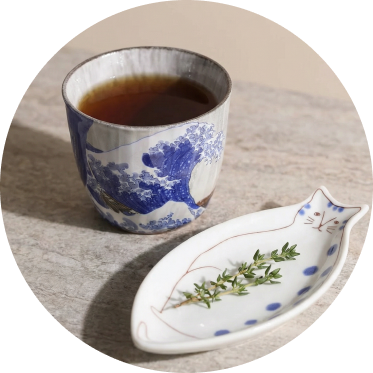 Japanese ceramic teacup with waves of kanagawa design and a cat-shaped sauce plate setting