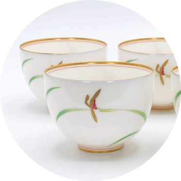 Three japanese ceramic cups with decorative designs on a white background