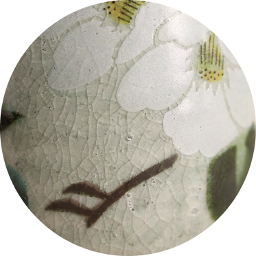 Close-up of a ceramic teacup with floral design, showcasing the glaze quality