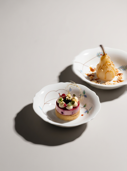 Two small desserts on japanese porcelain white plates with a light background