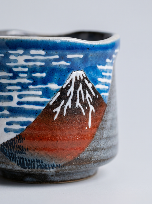 Close up of Kutani ceramic cup with Red Mount Fuji design on a light gray background