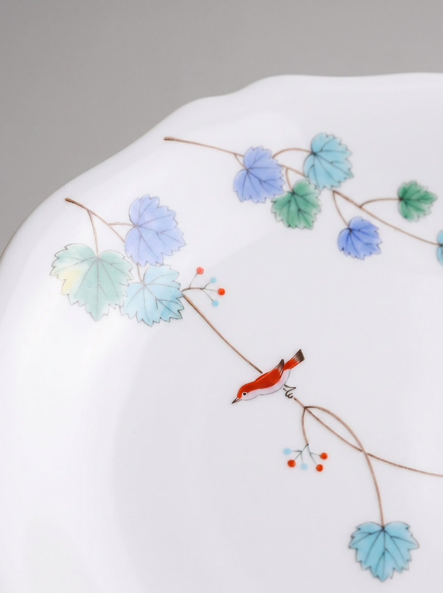 Close up of Japanese koransha porcelain dinner plate with floral design on a gray background