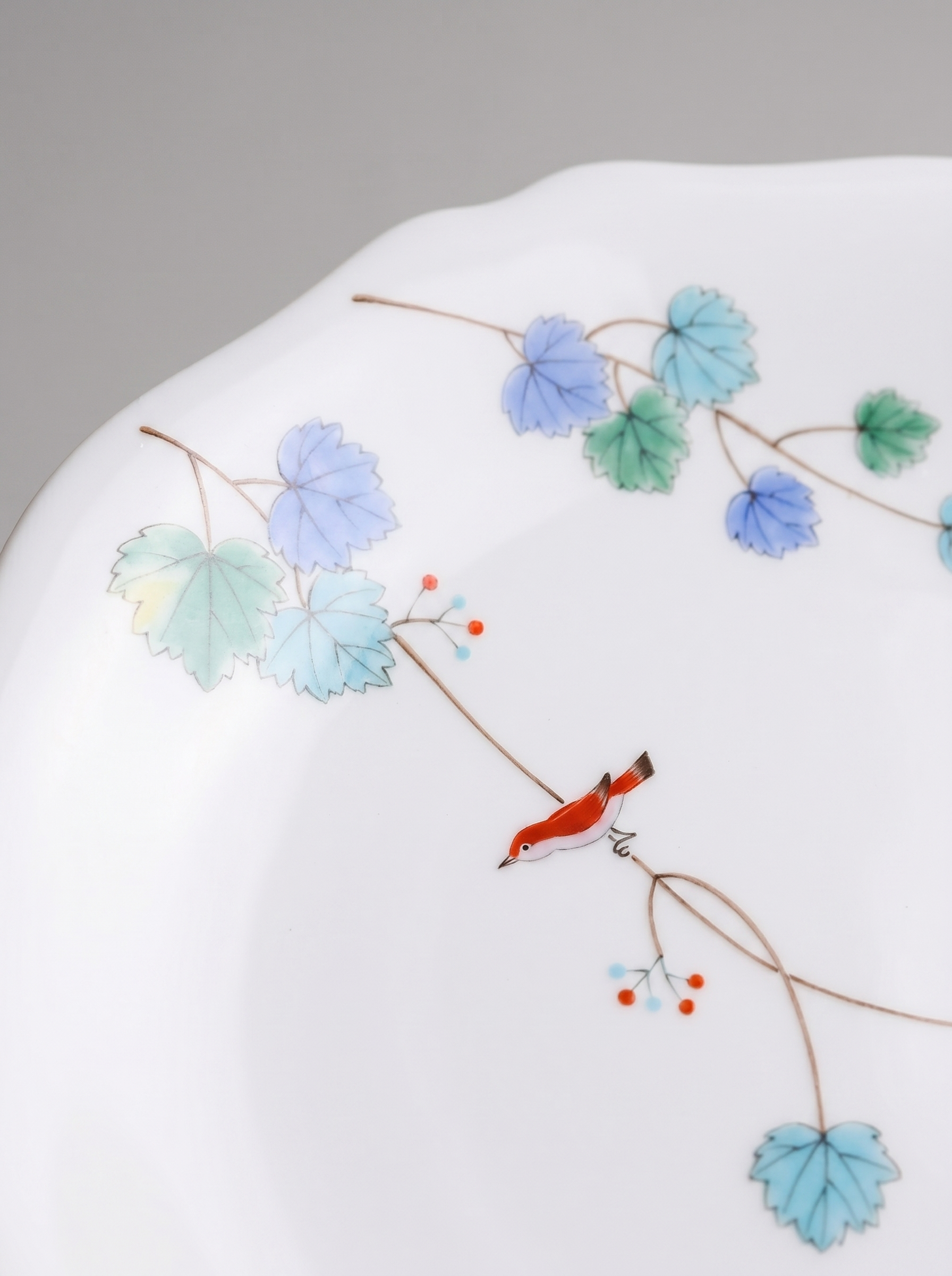 Close up of Japanese koransha porcelain dinner plate with floral design on a gray background