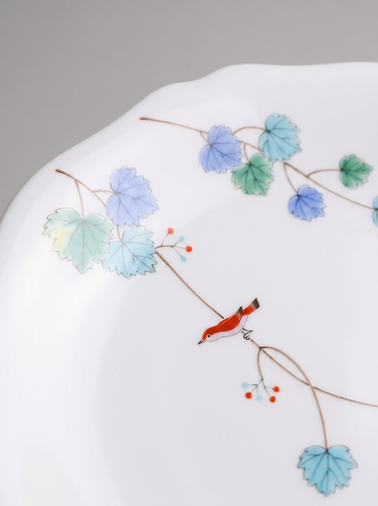 Close up of Japanese koransha porcelain dinner plate with floral design on a gray background