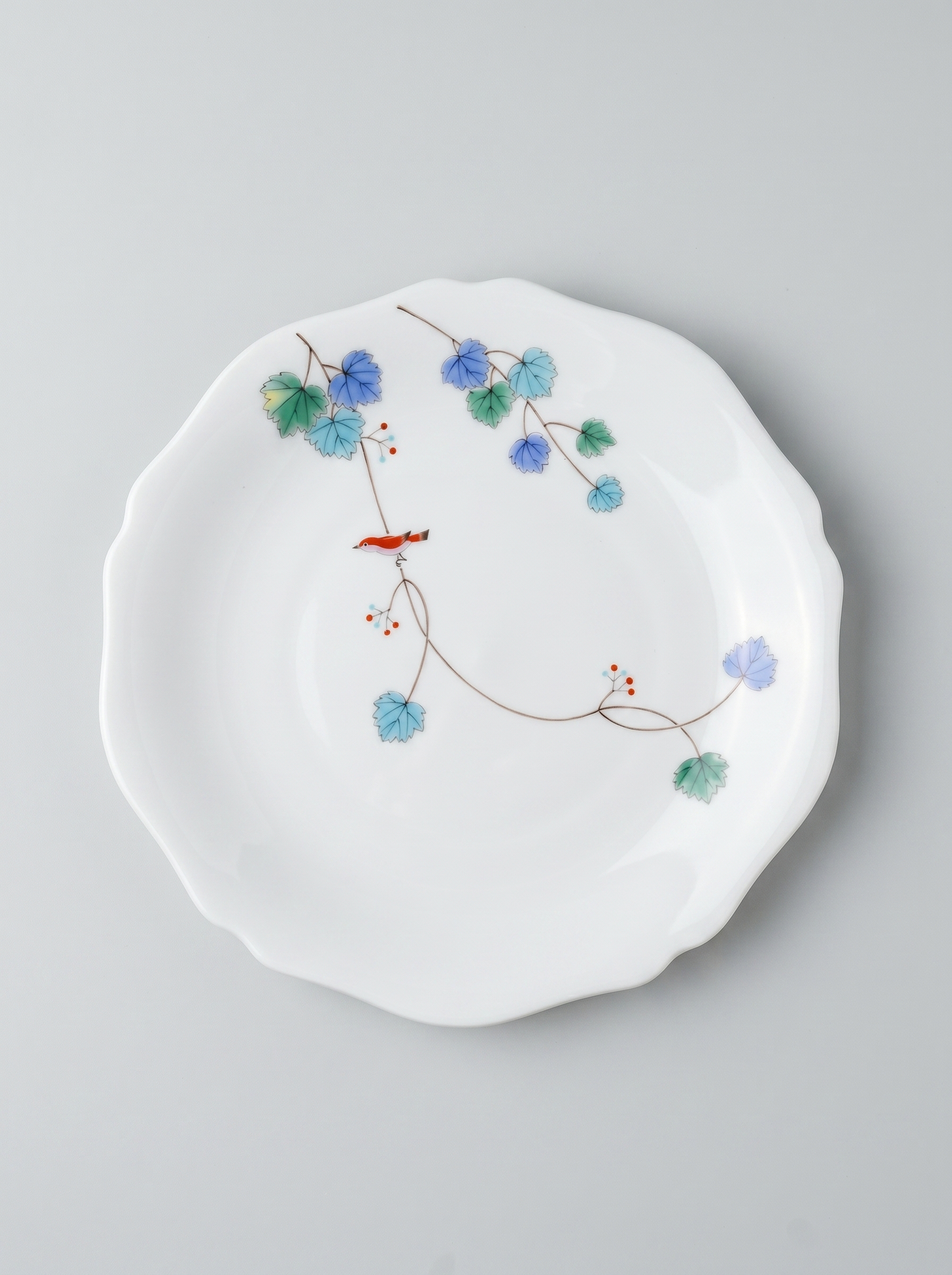 Japanese koransha porcelain dinner plate with floral design on a gray background