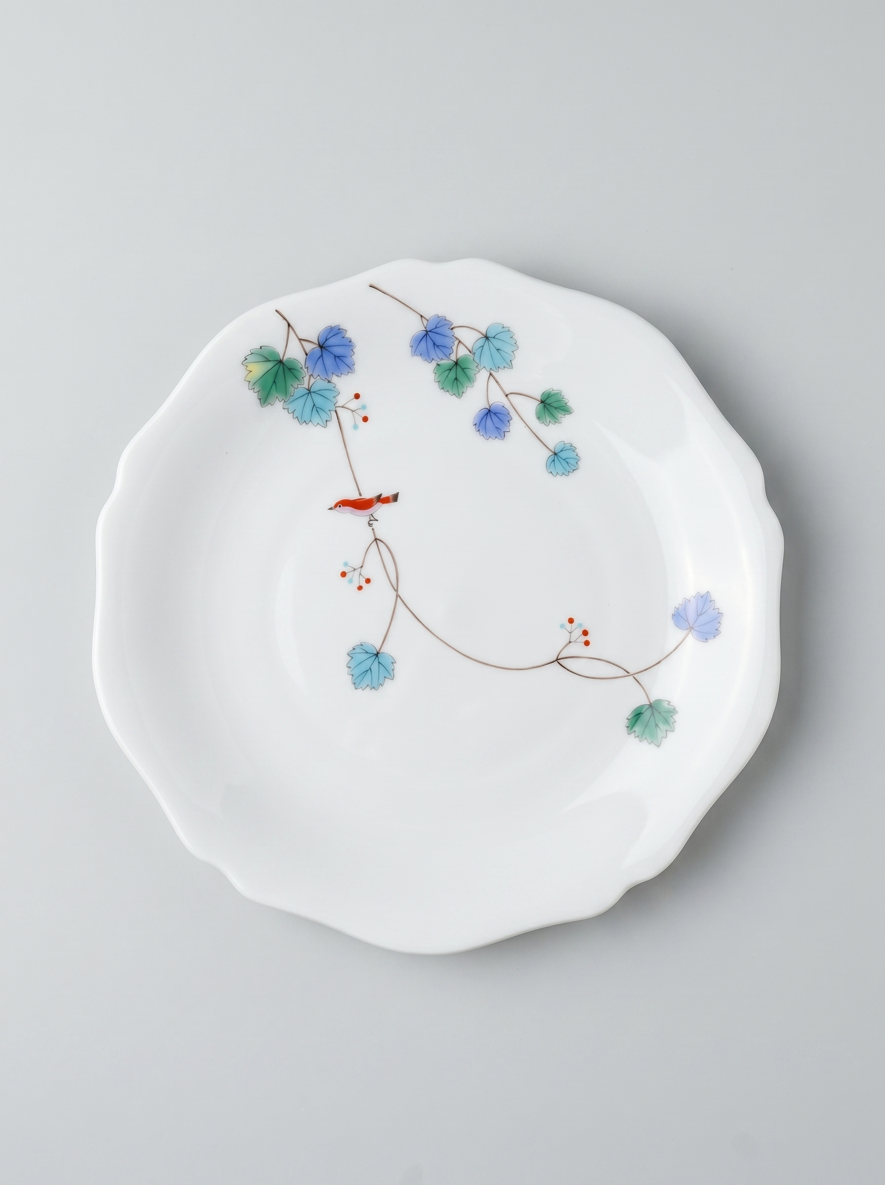 Japanese koransha porcelain dinner plate with floral design on a gray background