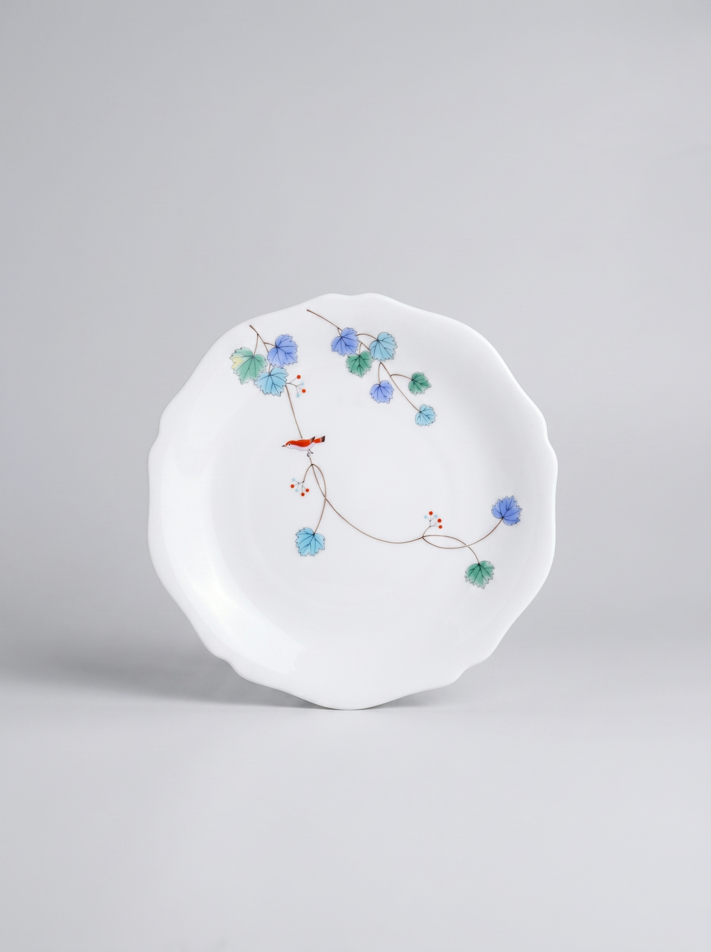 Japanese koransha porcelain dinner plate with floral design on a gray background