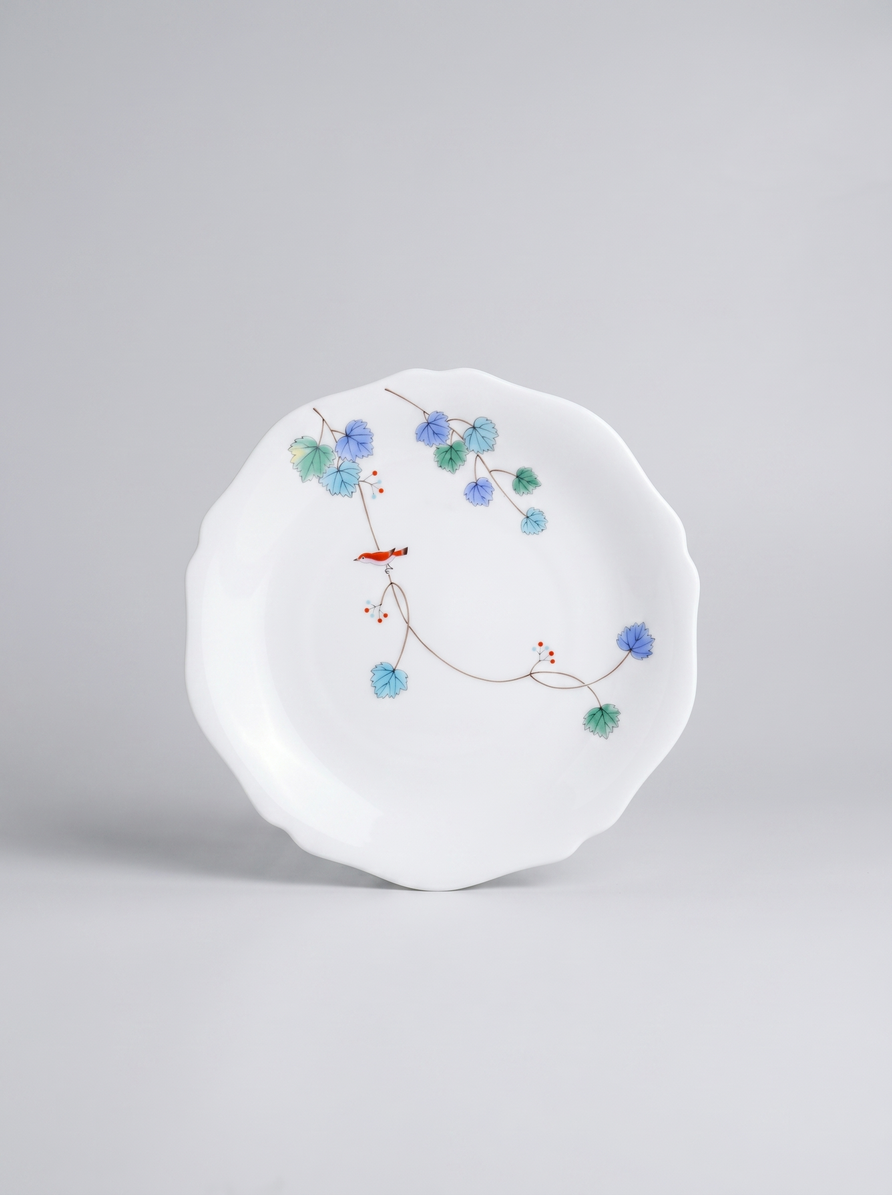 Japanese koransha porcelain dinner plate with floral design on a gray background