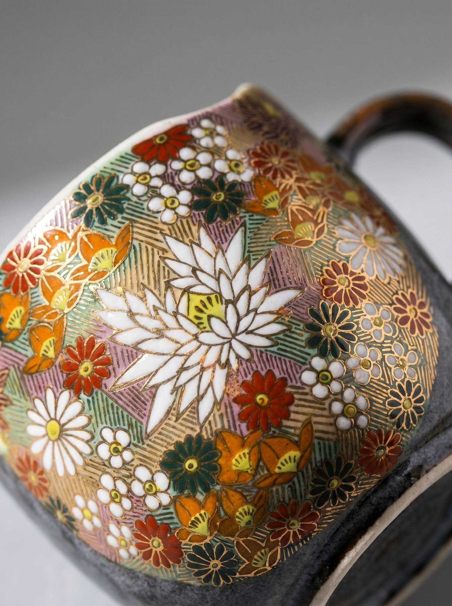 close up of Japanese hanazume ceramic mug with floral pattern on a light gray background
