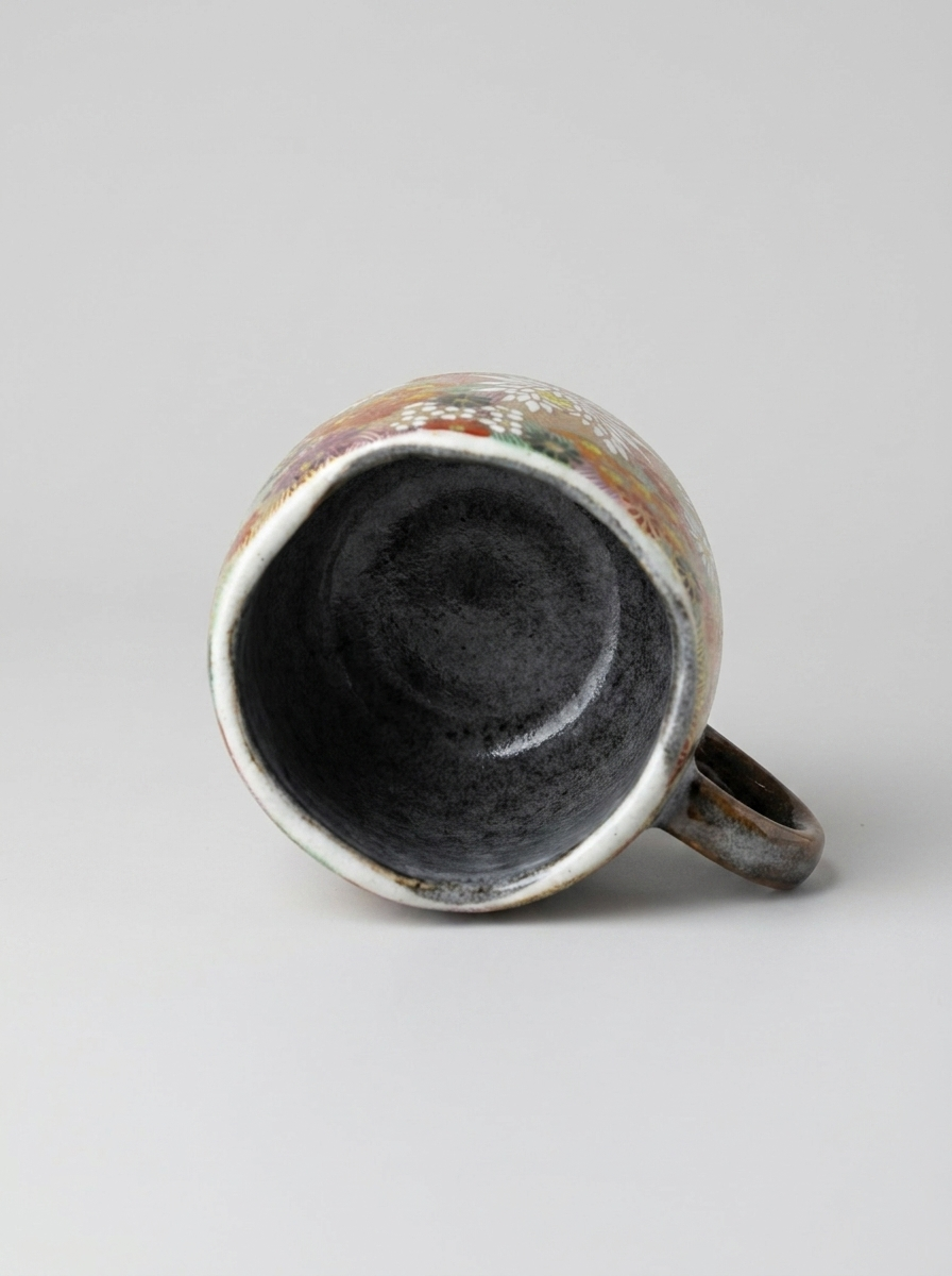 Japanese hanazume ceramic mug with floral pattern on a light gray background, showcasing the surface