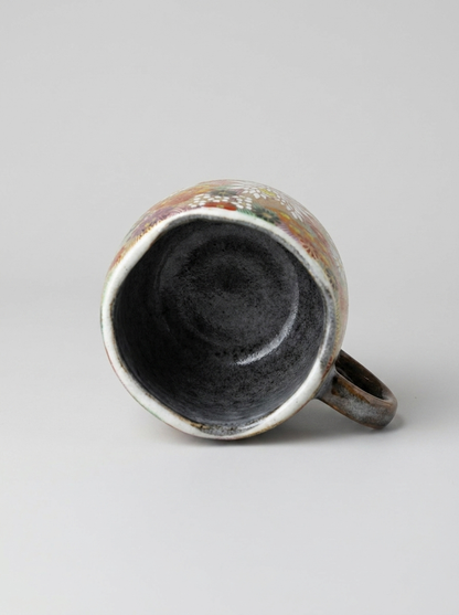 Japanese hanazume ceramic mug with floral pattern on a light gray background, showcasing the surface