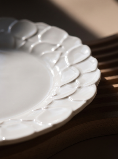 macro view of a white Japanese koransha decorative plate with embossed surface on a beige background, showcasing its relief