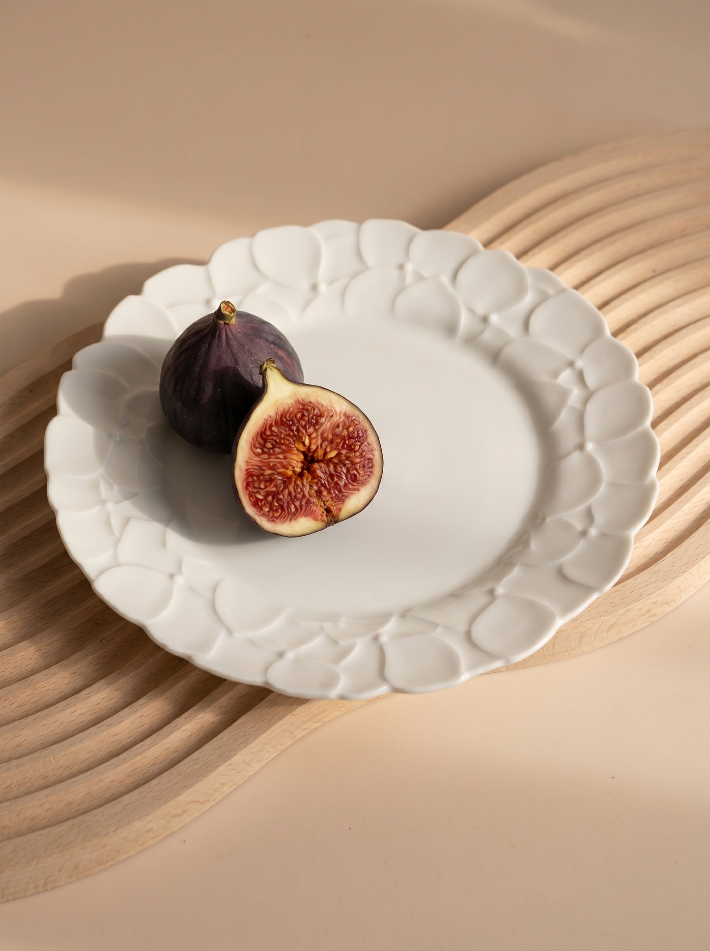 White Japanese koransha decorative plate with figs on a beige background