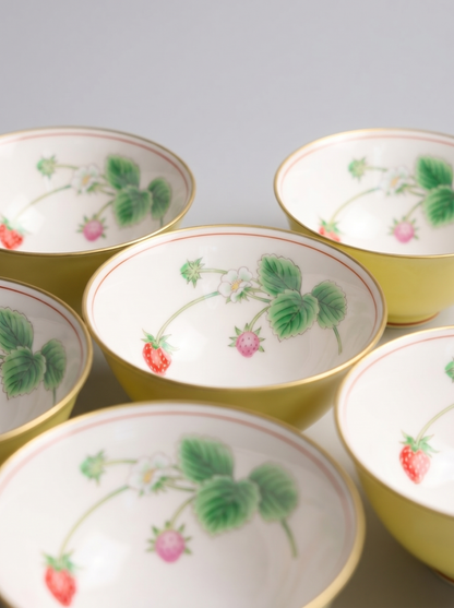 Set of ceramic bowls with berry patterns on a gray background