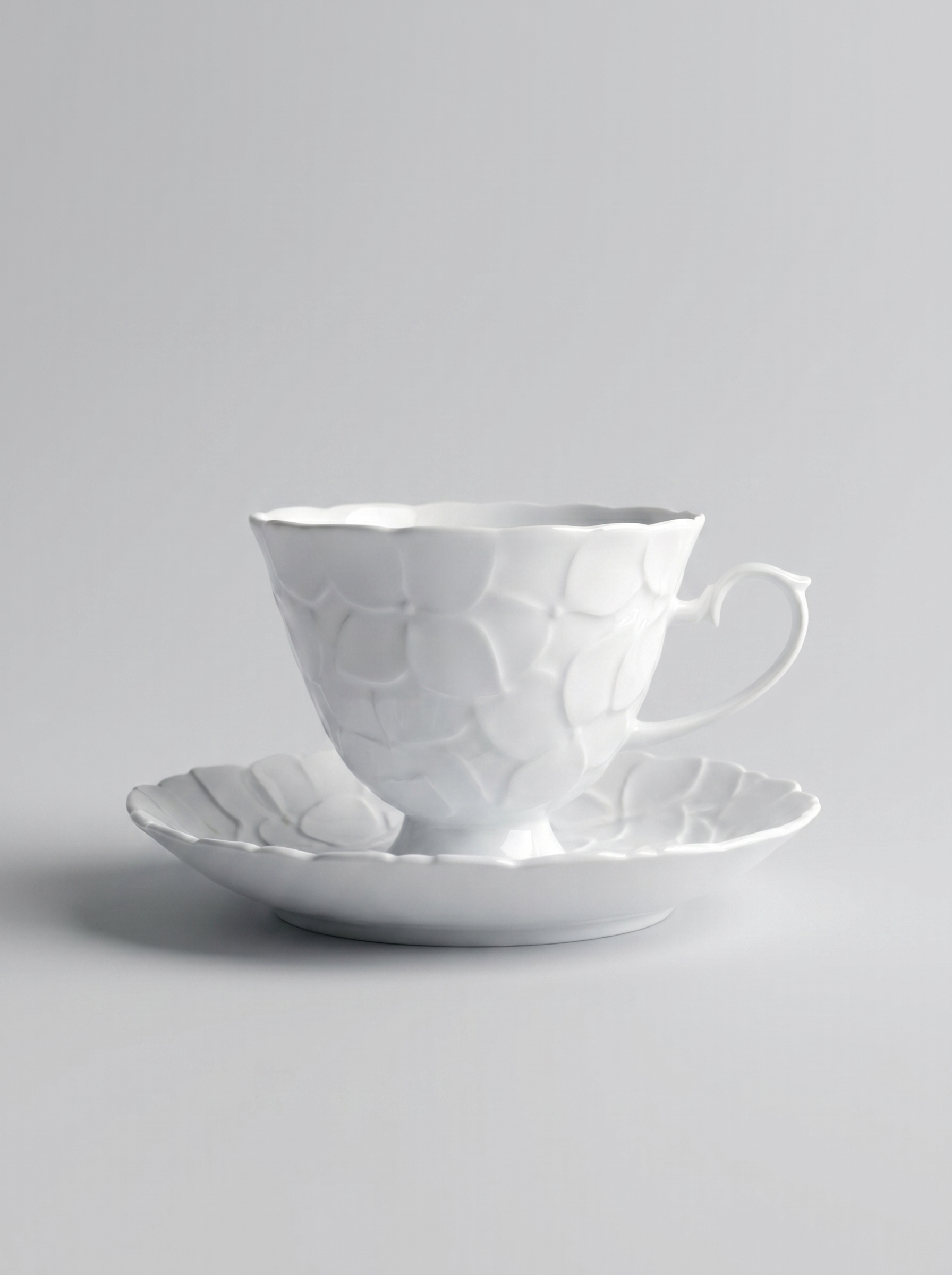 Japanese white koransha teacup with a short handle and a saucer on a sodt grey background