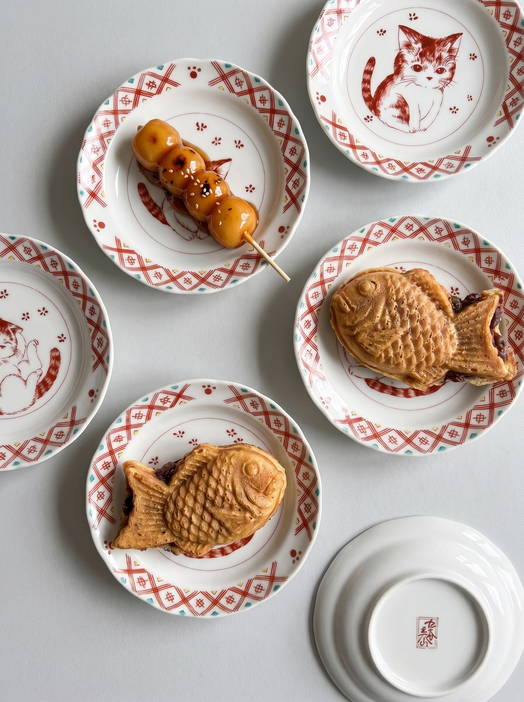 Decorative Japanese kutani plates with food items on a light gray background