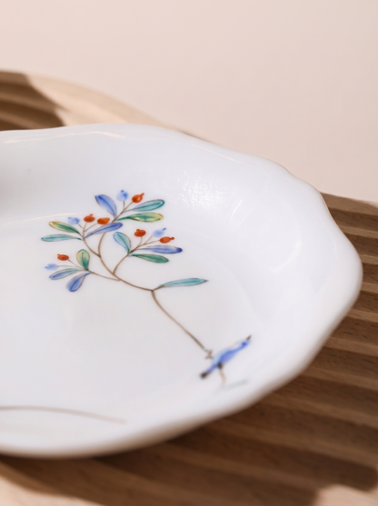macro view of japanese porcelain dessert plates with floral patterns on a grey background