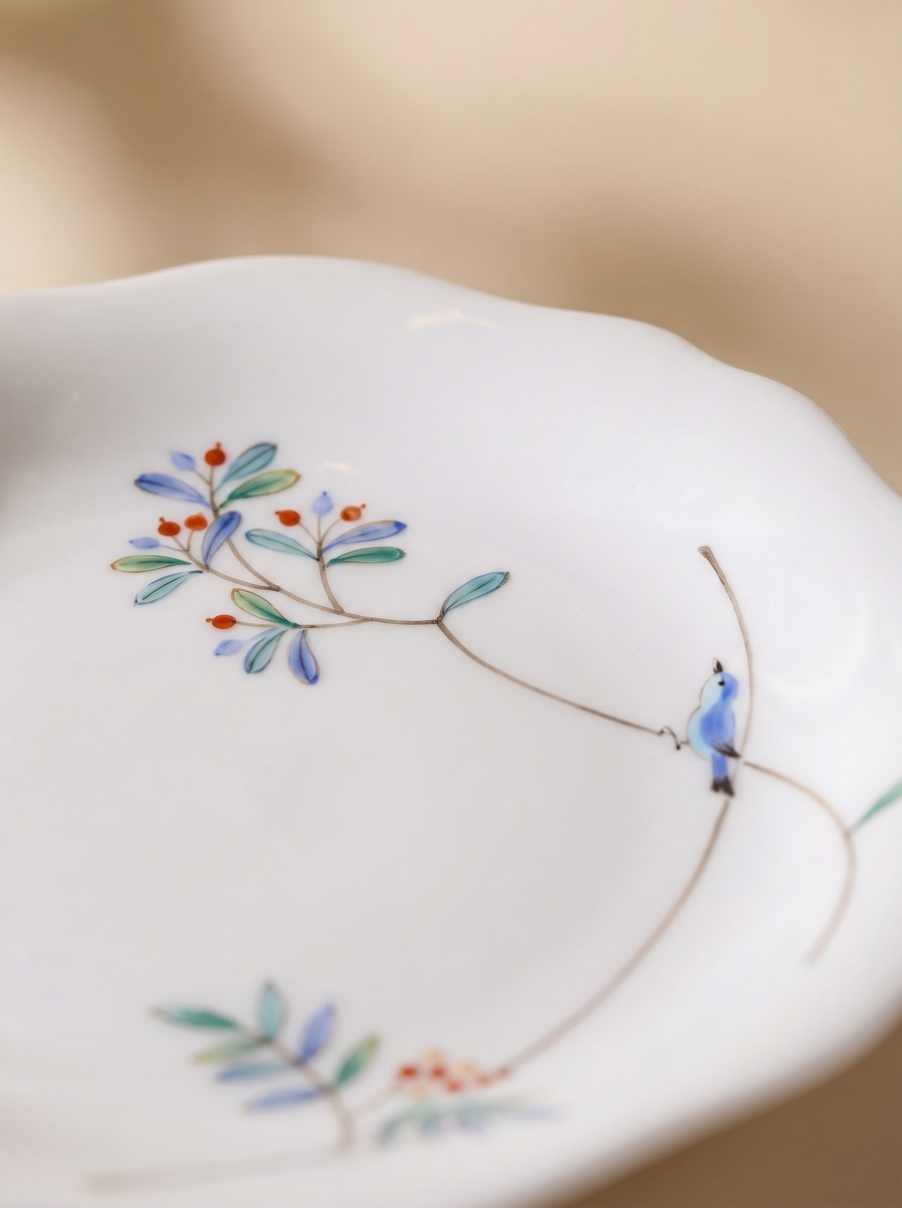 macro view of japanese porcelain dessert plates with floral patterns on a beige background