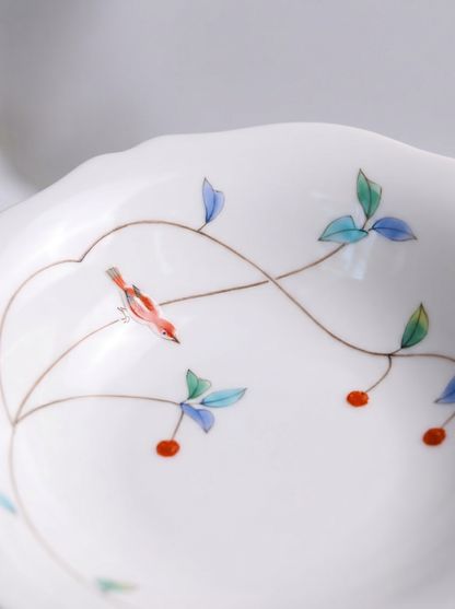 Two white japanese koransha porcelain bowls with floral patterns on a light gray background