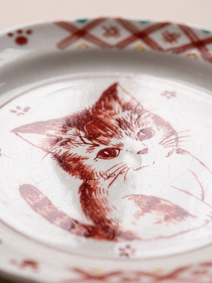 Decorative plate with a red cat illustration on a white background