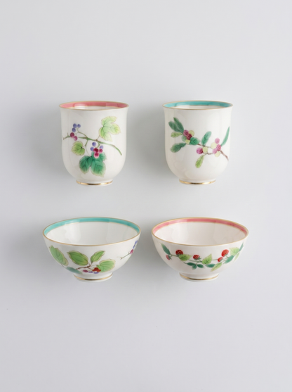 Set of four Japanese koransha porcelain cups with floral designs on a light gray background