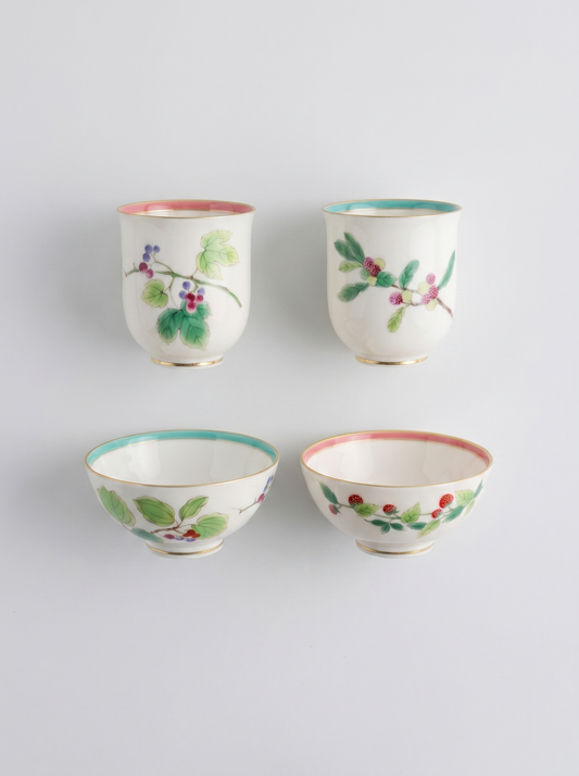 Set of four Japanese koransha porcelain cups with floral designs on a light gray background