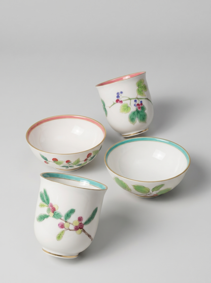 Set of four Japanese koransha porcelain cups with floral designs on a light gray background