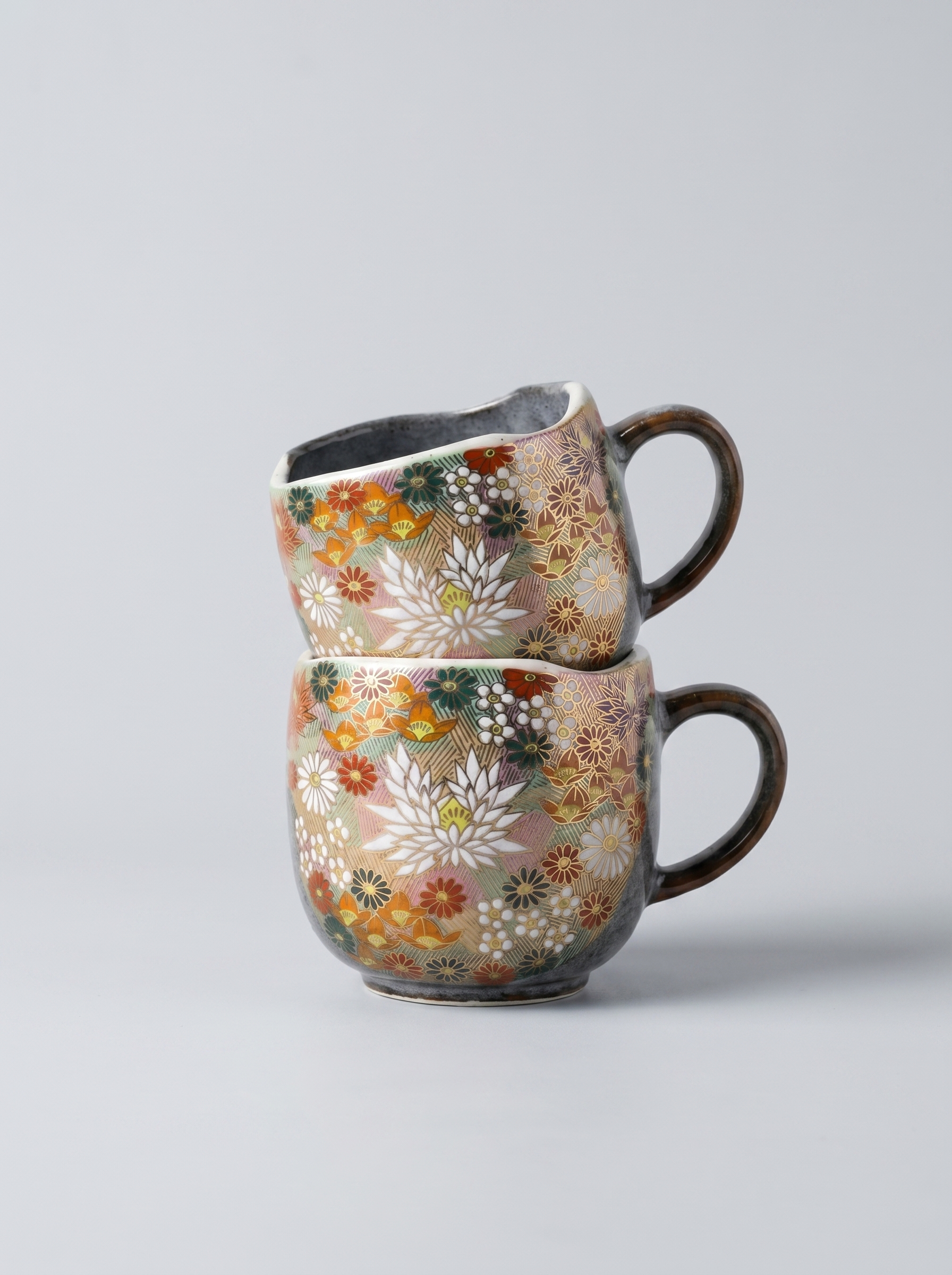 stack of 2 Japanese hanazume ceramic mugs with floral pattern on a light gray background