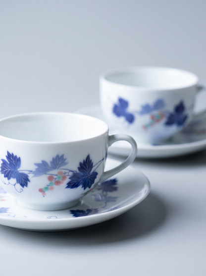 Two ceramic cups with floral patterns on saucers against a light background