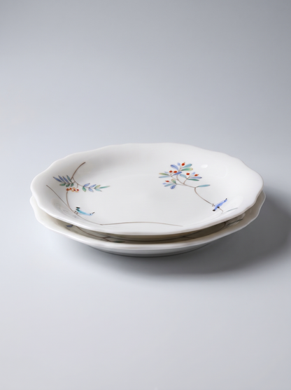 Two white ceramic plates with floral designs on a light gray background