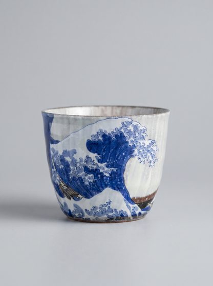 Japanese kutani ceramic teacup with The Great Wave off Kanagawa design with no handle on a grey background