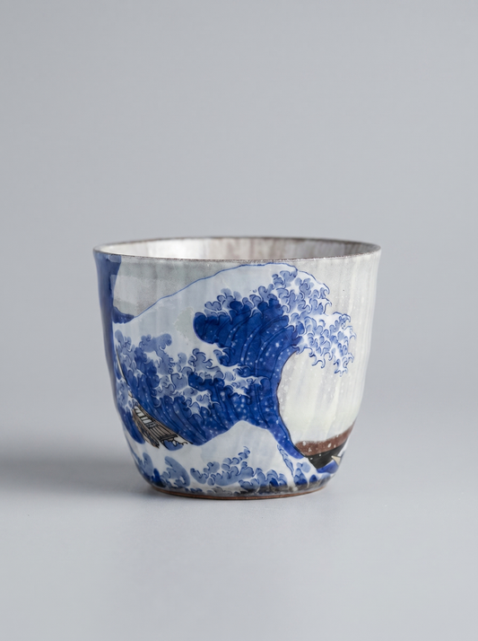 Japanese kutani ceramic teacup with The Great Wave off Kanagawa design with no handle on a grey background