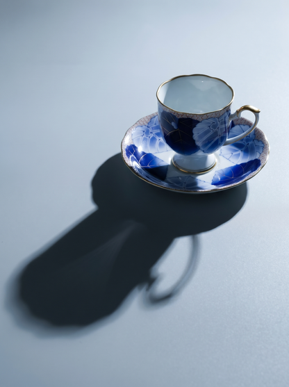 Blue and white porcelain teacup and saucer on a light gray background