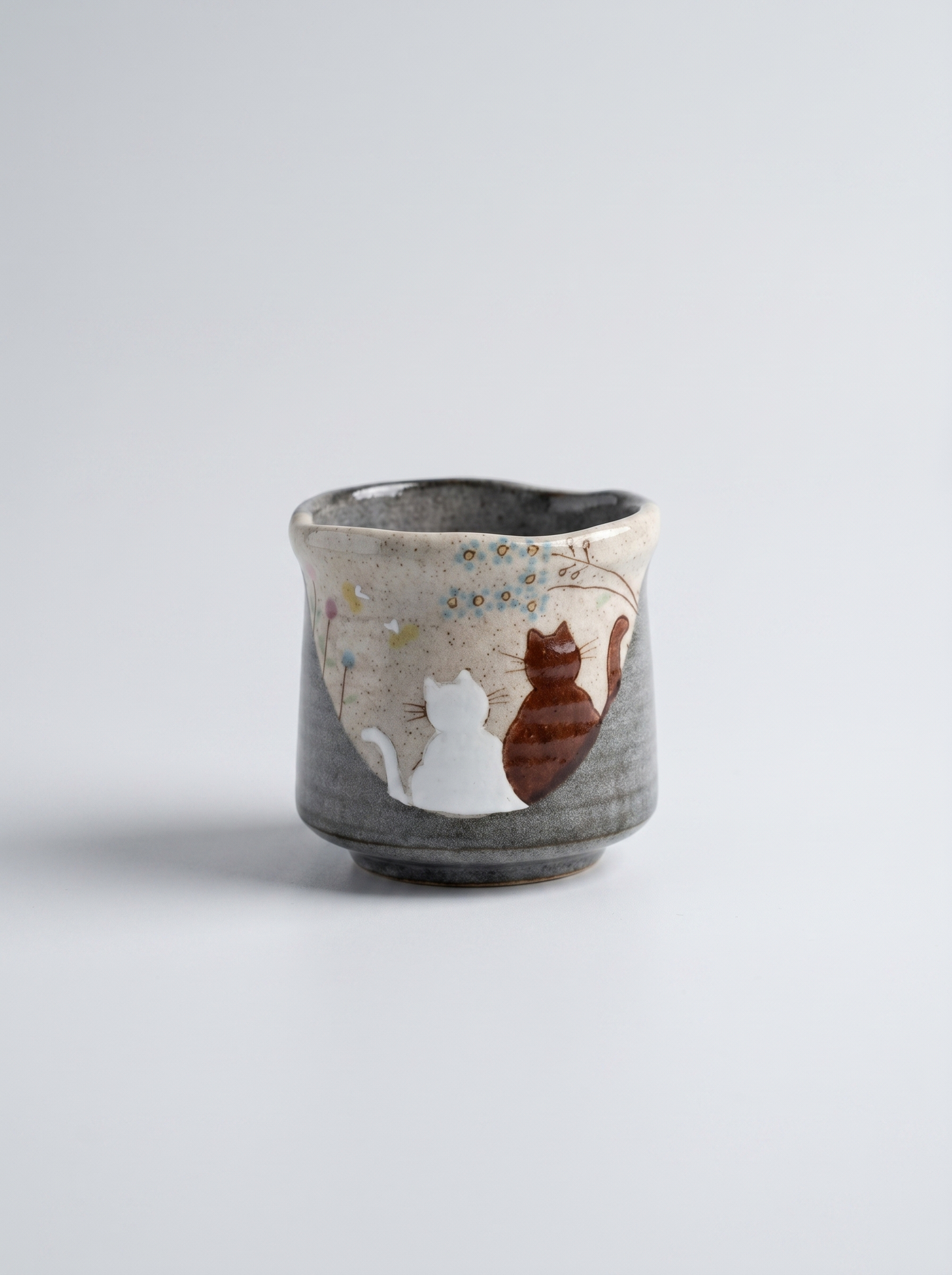 Japanese ceramic kutani teacup with no handle with cats in sunny spot yunomi hand-painted illustration design on a light grey background