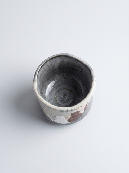 Small ceramic cup with a animal pattern on a white background top view