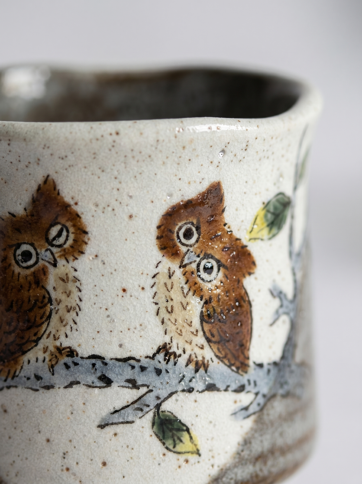 Close up of a Japanese ceramic kutani teacup with owl design on a white background