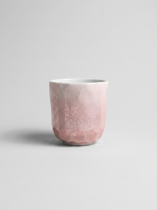 Japanese pink ceramic cup with ginsai finish on a light gray background