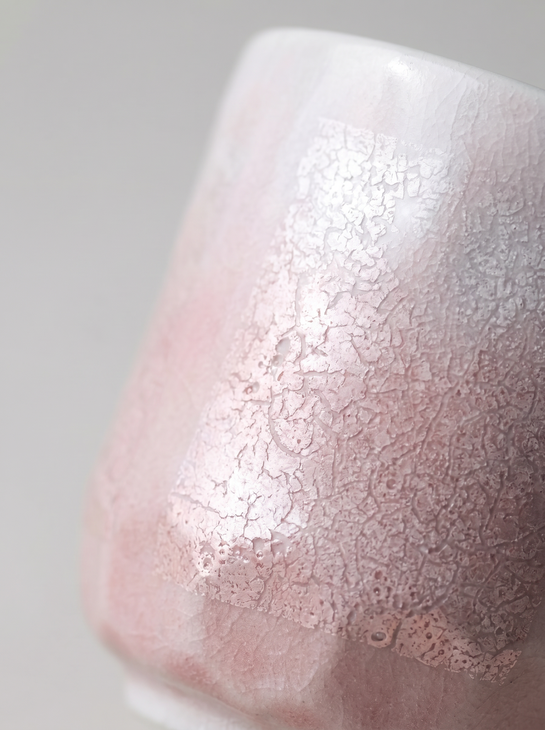 Close-up of a ginsai finish surface, pink teacup on a gray background