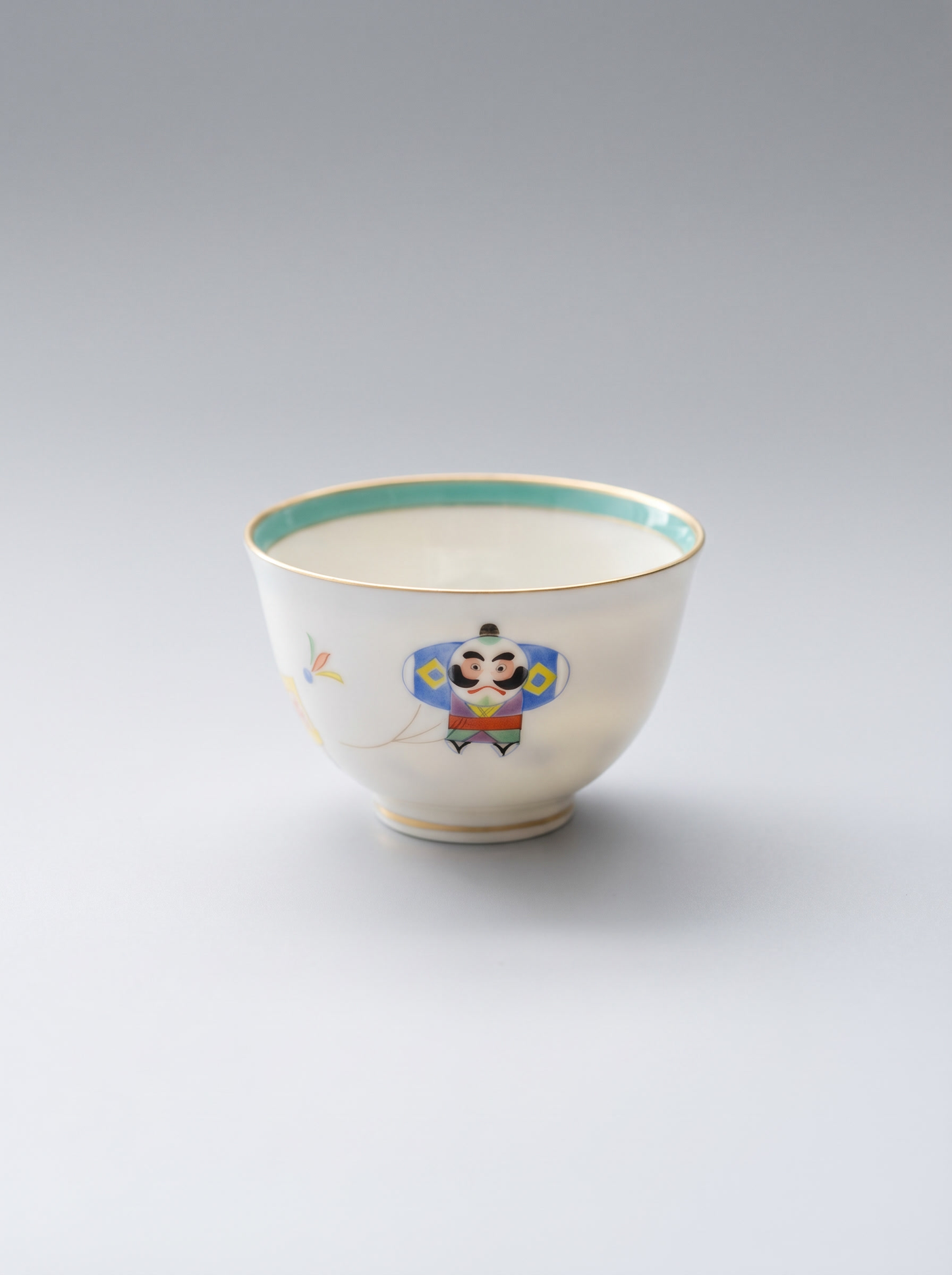 porcelain teacup with a decorative hand-painted design on a plain background