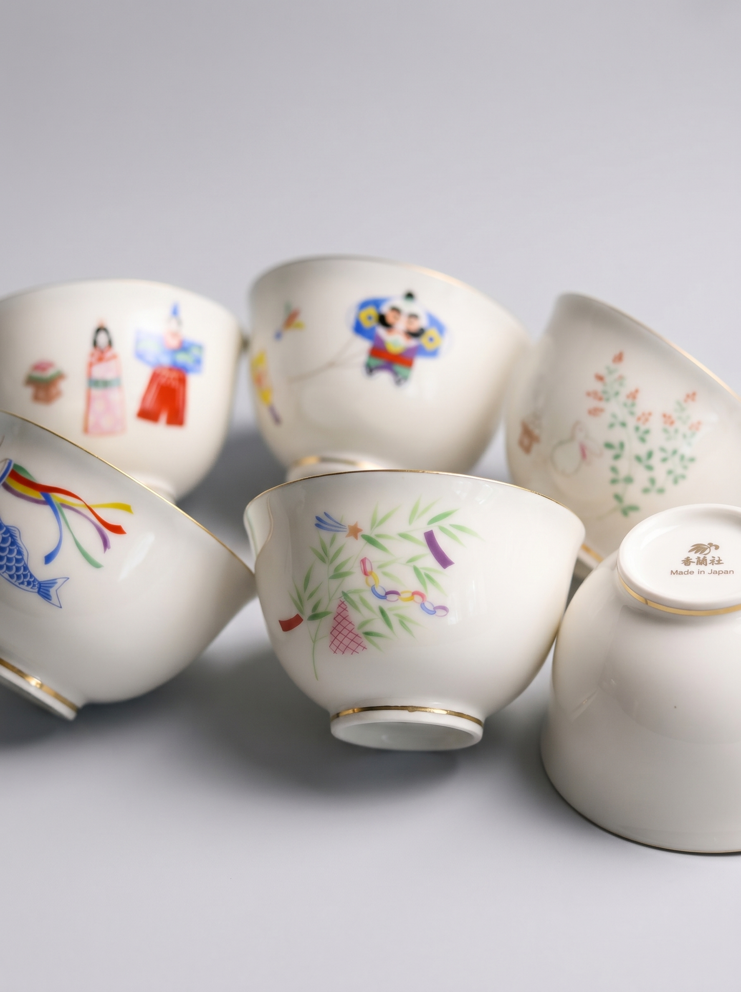 Set of ceramic cups with colorful designs on a light gray background