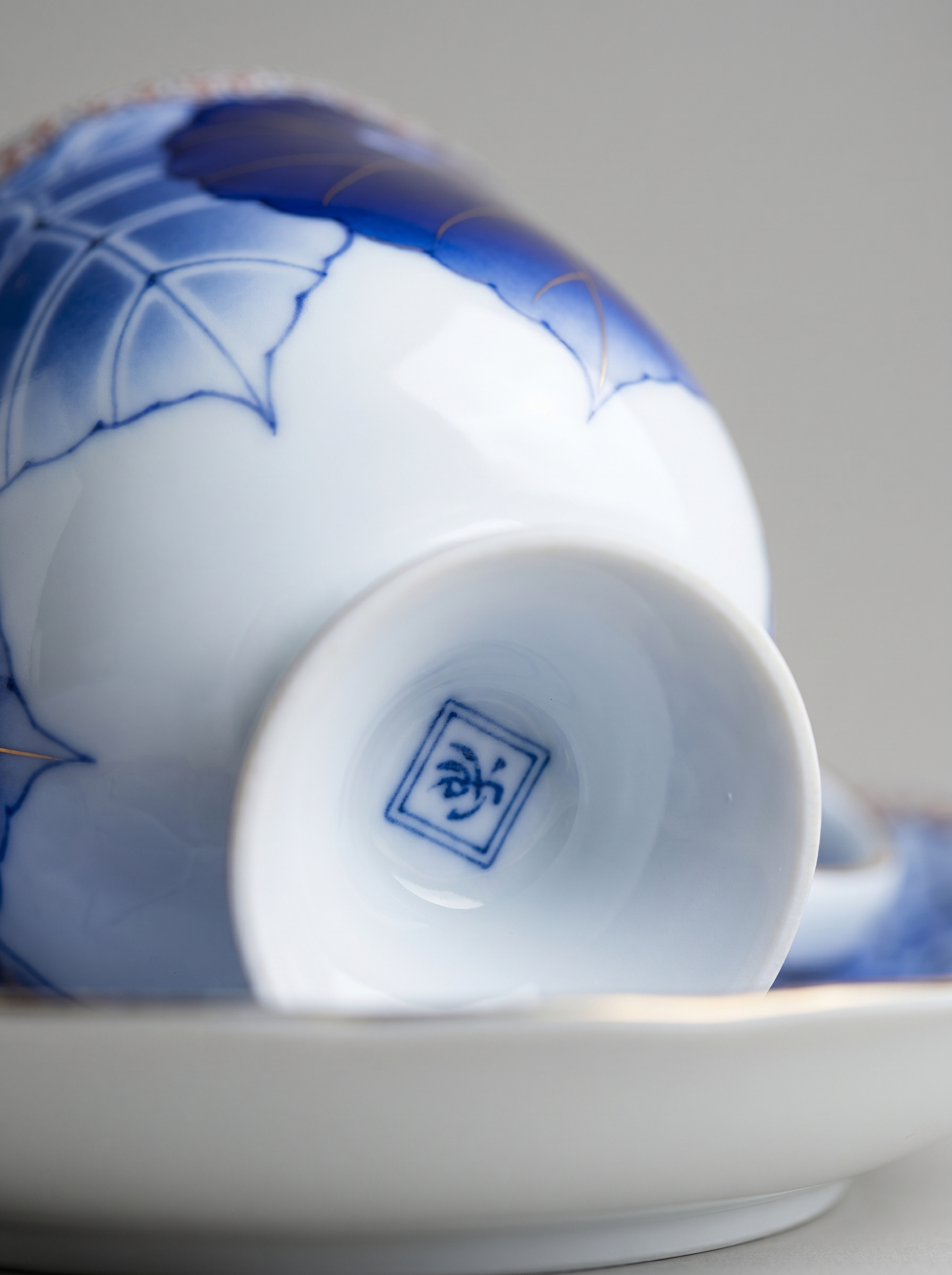 Ceramic bowl with blue floral design and a visible Japanese marking on a white background