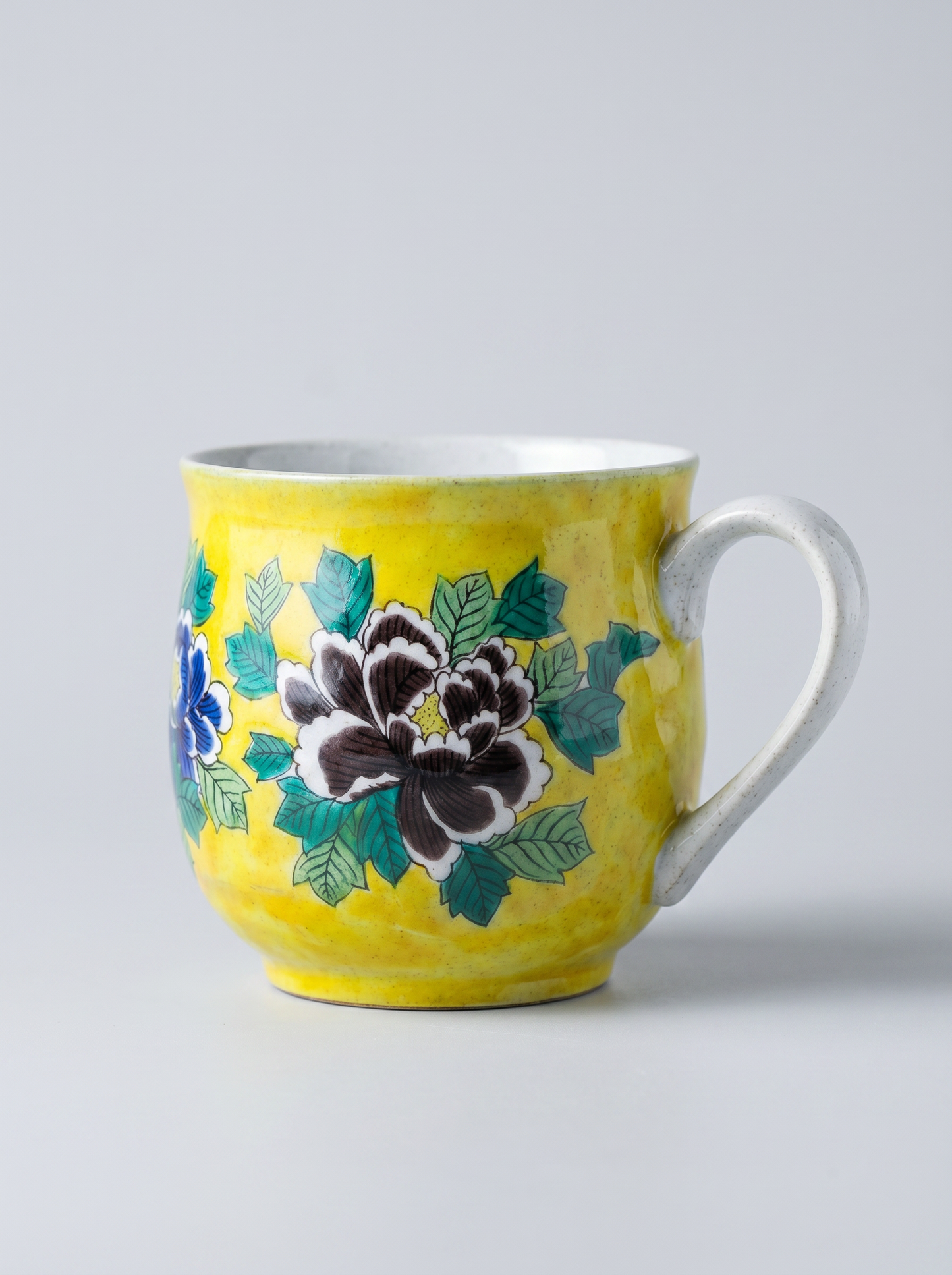 Yellow mug with floral design on a gray background