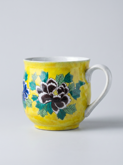 Yellow mug with floral design on a gray background