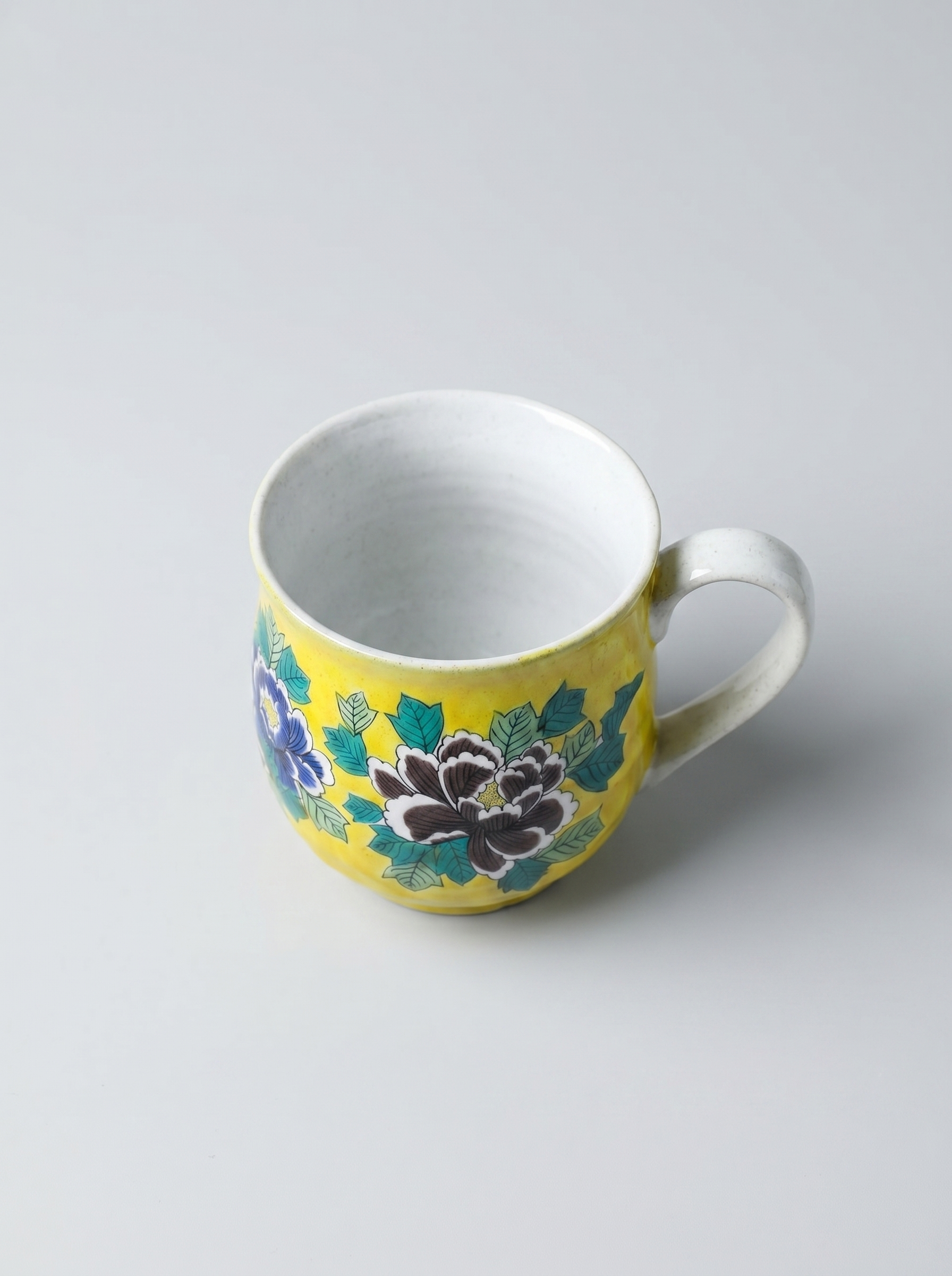 Ceramic mug with floral design on a grey background