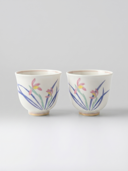 Two Japanese koransha porcelain teacups with floral designs on a light gray background