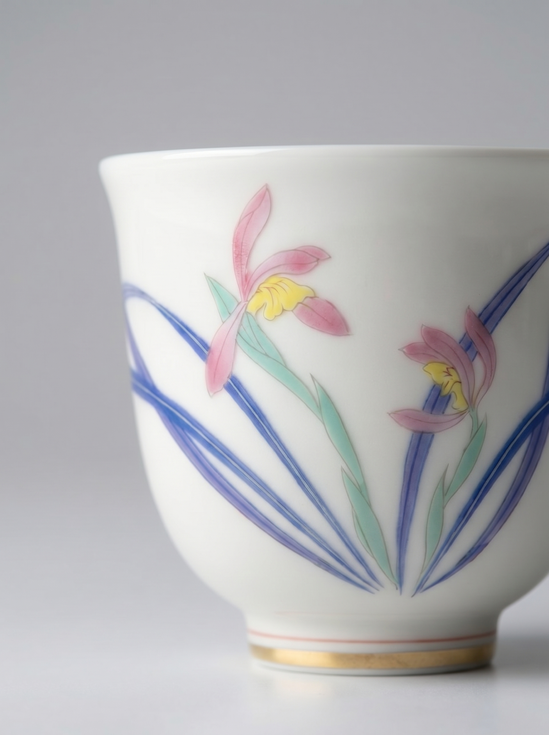 Close up of a porcelain cup with floral design on a gray background
