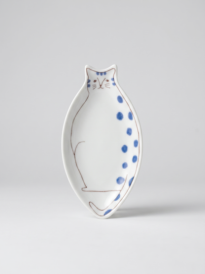 Japanese cat-shaped kutani ceramic sauce plate with blue polka dots on a light gray background
